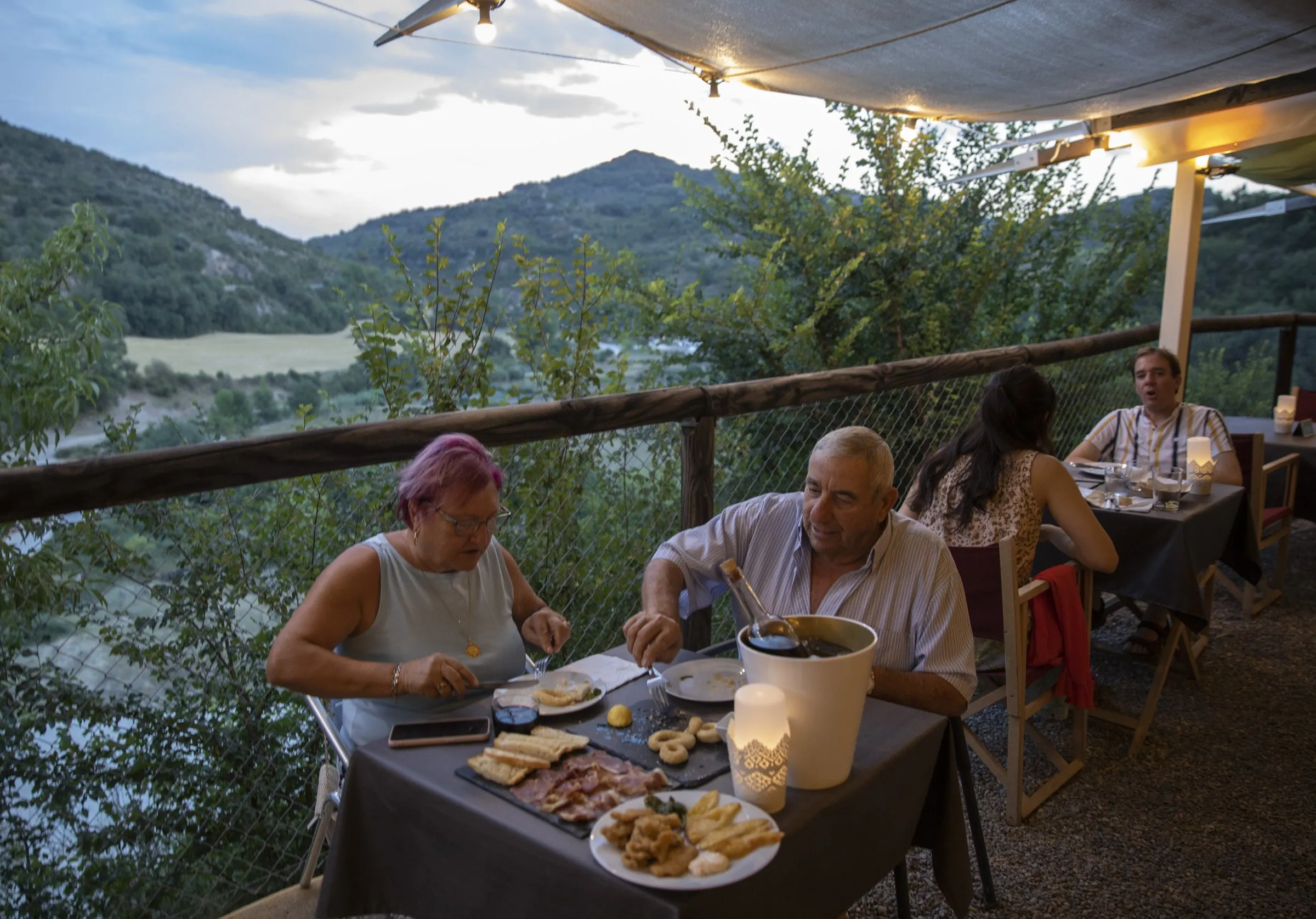 Una pareja comparte platos en la terraza con vistas al valle